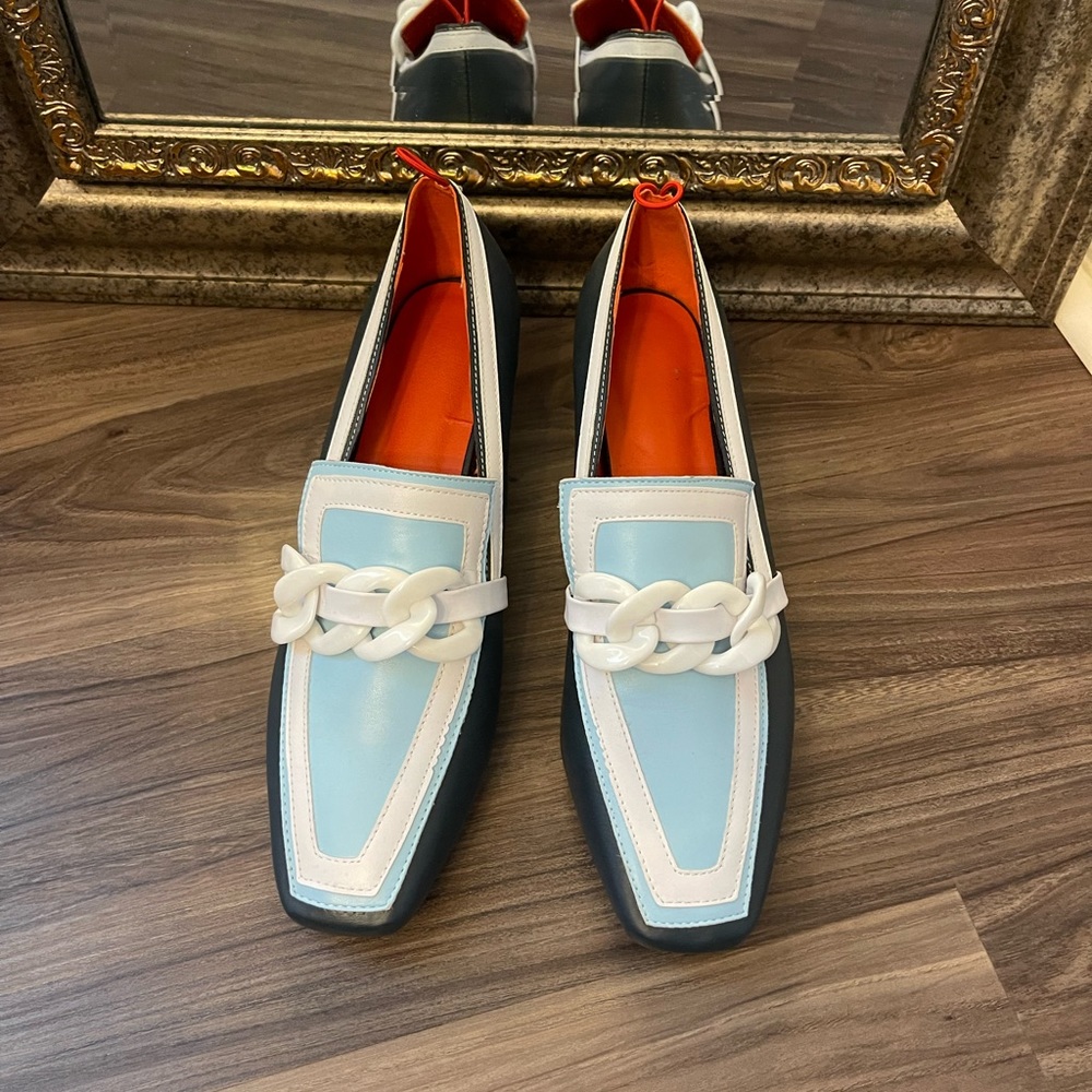 Woman’s dress shoes, navy, light blue, and white with a red insert.